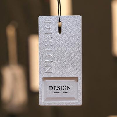 China Sustainable Wholesale Hangtags Customized Special Paper Embossed Logo Tag Design Hang Tags For Clothing for sale