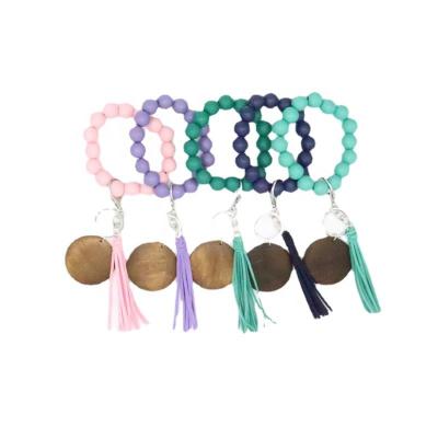 China Factory wholesale trendy custom wooden beads bracelet elastic cord with log piece tassel key chain for sale