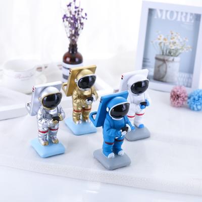 China Creative Europe Ornaments Resin Craft Space Astronaut Mobile Phone Desktop Stand for sale