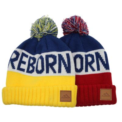 China Custom Promotional Jacquard Knitted Three Patch Logo COMMON Tone Pom Pom Beanies Hat With Edge Cuff for sale