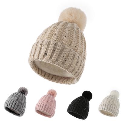 China JOINT Logo Jacquard Knitted Furry Lining Custom Skull Caps with Single Faux Fur Pom for sale