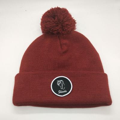 China Burgundy Solid Color COMMON Plain Dyed Pom Pom Knitted Hat With Custom Woven Patch for sale