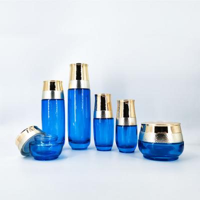 China Empty Blue Transparent Cosmetic Glass Bottle 30g 50g 40ml-120ml Suit Bottle Luxury Hua Jin Crown Skin Care Suit Personal Care for sale