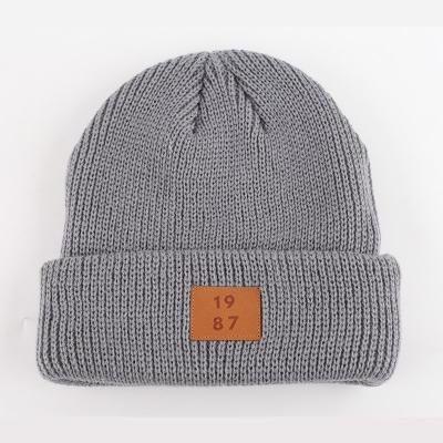 China JOINT Custom Knitted Ribbed Beanie Hats With Leather Patch Skull Hats for sale