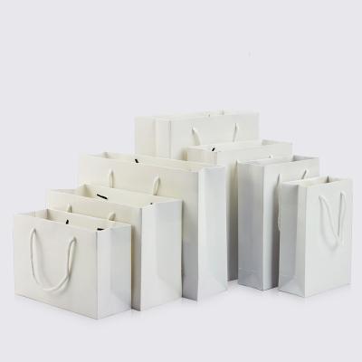 China Recyclable white portable paper bag holiday packaging gift storage clothing shopping bag support printing 1 color simple logo for sale