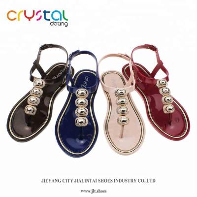 China PVC Ladies T-shape Flat Plastic Sandals With Gold Shell Accessories for sale