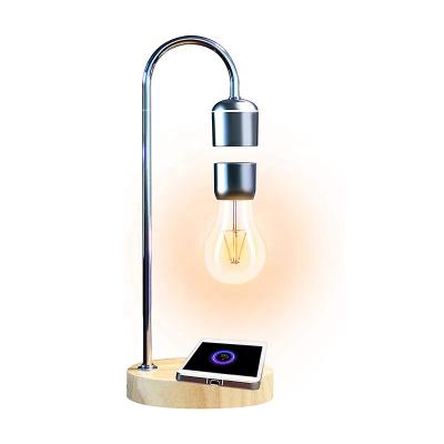 China Unique Cell Phone Gifts Desk Toys Magnetic Floating Desk Led Bulb Levitating Lamp With Wireless Charger Wooden Base for sale