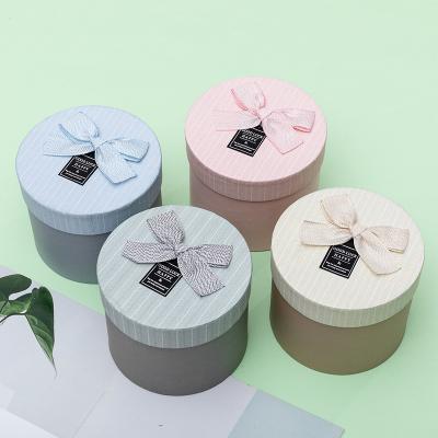 China Creative Recycled Materials Small Perfume Box Round Hand Creative Happy Box High Quality Custom Packing Box for sale