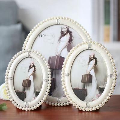 China Alloy Photo frame custom oval white pearl photo frame set  European palace creative style decoration senior vintage photo frame for sale