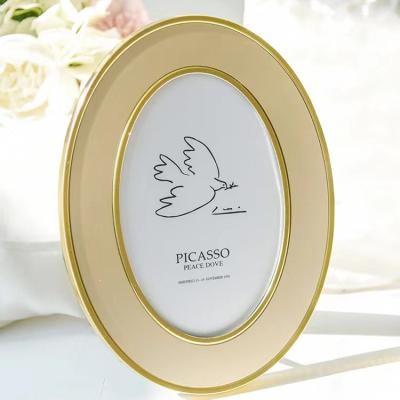 China Alloy Photo frame custom oval golden aluminum alloy photo frame light luxury 6 inch 7 inch wedding photo wedding holiday gift for sale