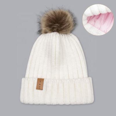 China COMMON Adult Women White Custom Leather Label Ribbed Cuff Faux Fur Ball Pom Pom Beanie Hat for sale