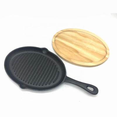 China Easily Cleaned Oval Cast Iron Griddle Skillet Grill Casserole With Wooden Handle And Tripod Base for sale