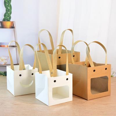 China Recycled materials wholesale portable smiling face square paper bag holiday shopping bags with logo for sale