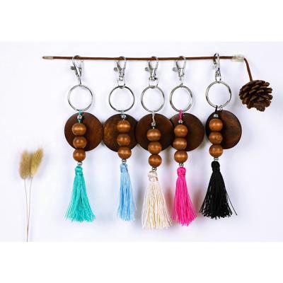 China Elastic Wood Beads Cotton Tassel Key Chain Trendy Monogram Wood Around Disc Beads Wooden Tassel Key Chain For Girls Lady Keyring for sale