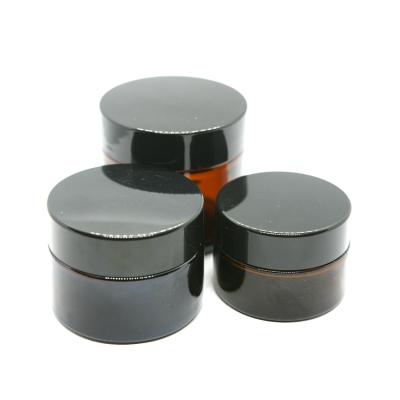 China UV proof high quality amber color glass jar for cosmetic cream with glossy black screw cap for sale