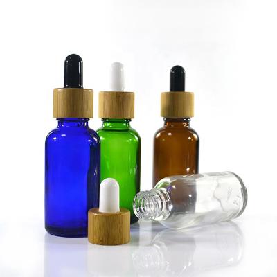 China Amber Blue Green Glass Serum Cosmetic Luxury Dropper Essential Oil Clear Bottle With Bamboo Lid for sale