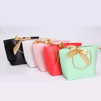 China Recycled Materials Tied Ribbon Bowknot Apparel Tote Bag Colorful Gift Paper Bag Bullion Shape Tote Bag for sale