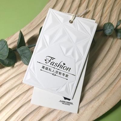 China Luxury Custom Hang Paper Tags With Logo Design And Printing Of Fashion Garment Tag Embossed Apparel Swing Tag With String for sale