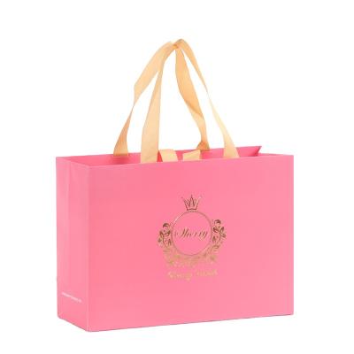 China Custom Logo Rose Gold Hot Stamping Garment Packaging Paper Bag Recyclable With Ribbon Handles for sale