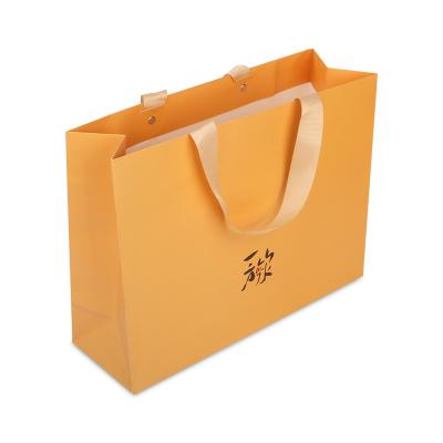 China Recyclable Custom Logo Printing Apparel Packaging Paper Shopping Bags With Ribbon Handles for sale