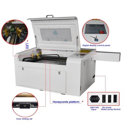 China Laser CUTTING CO2 60w laser engraving and cutting machine 400*600mm with electric through honeycomb platform for making small crafts for sale