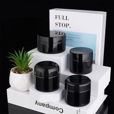 China Luxury Skincare Packaging 60g 100g Black Glass Round Curved Cream Jars ABS lids For Face Eyes Cream for sale