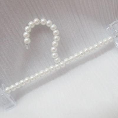 China Minimalist White Acrylic Custom Hangers ABS Plastic Clothes Pearl Bead Trouser Clip Laundry Hangers for sale