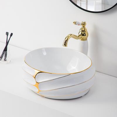 China Modern Hotel Countertop Bathroom Sink White Art Decorative Oval Ceramic Basin And Gold Hand Face Ceramic Basin for sale