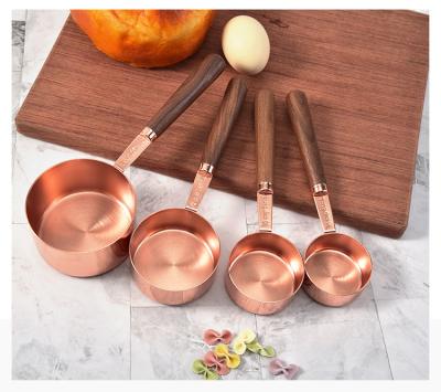 China New Stocked Style Kitchen Measuring Baking Tools Rose Gold Color 8PCS Measuring Cups And Spoons With Walnut Wood Handle for sale