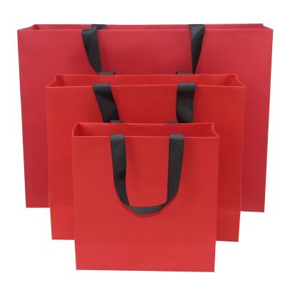 China Recyclable Splendid Paper Carry Bag Beauty Shop Jeans Clothing Packaging Printed Red Luxury Gift Customized Shopping Paper Bags With Logo for sale