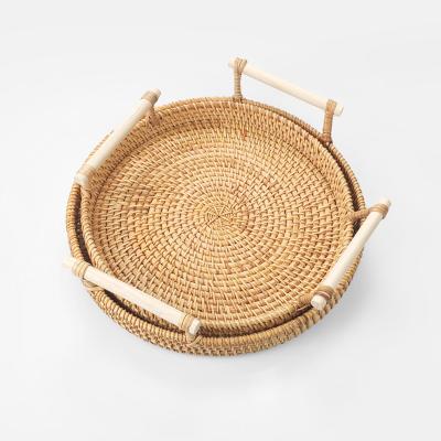 China Sustainable Handwoven Rattan Storage Tray With Wooden Handle Round Rattan Basket Bread Food Dish Fruit Cake Tray Dinner Serving Tray for sale