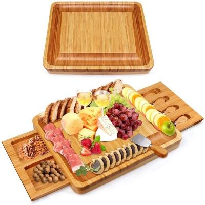 China Sustainable Bamboo Meat Charcuterie Tray Cheese Board Serving Tray With Two Hidden Slide Out Of Drawers 4 Cutlery Set for sale