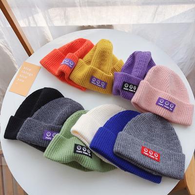 China Woolen Solid Color Baby Soft Hats Autumn And Winter Boys And Girls Handsome Face Beanie Smile Hat for sale