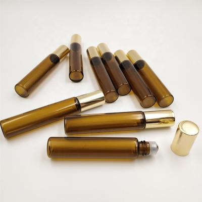 China 10ml 10cc cosmetic thick amber roll on glass bottle with stainless steel roller ball and gold aluminum screw cap for travel essential oil for sale