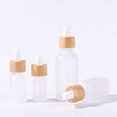 China Customized 5ml 10ml 15ml 20ml 30ml 50ml 100ml Cosmetic Bamboo Top Frosted Glass Essential Oil Dropper Bottle for sale