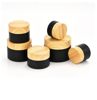 China 5G 10G 15G 20G 30G 50G 100G Matte Black Cream Jar Empty Cosmetic Bottle Large Wooden Cover Glass for sale