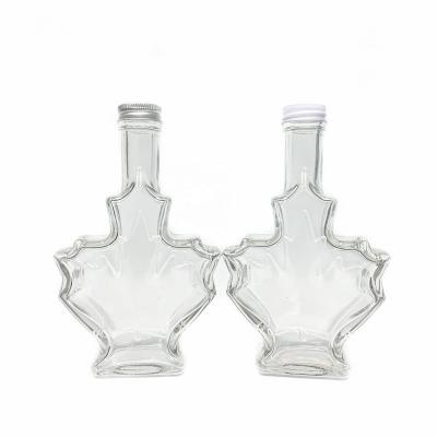 China Beverage 200ml Canada Maple Leaf Shaped Glass Bottles For Syrup Beverage Liquor With Aluminum Lid Screw Cap for sale