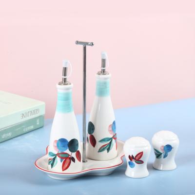 China Sustainable Underglazed Ceramic Salt and Pepper Shakers Condiment Serving Set Dressing Bottle with Metal Handle Ceramic Tray for sale