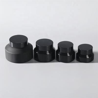 China 50ml Cosmetic Cream Packaging Jars Matt Black Round Glass Cosmetic Cream Jar With Black Cap for sale