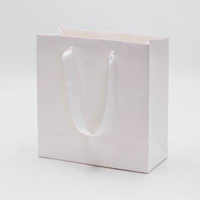 China Hot-selling Materials Luxury Custom White Ribbon Recycled Paper Gift Bag Design Shopping Logo With Handle for sale