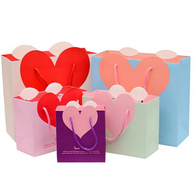 China Custom Materials Love Heart Clothing Bag Eco-friendly Hand Held Custom Logo Paper Bag Custom Gift Bag For Mall Shopping for sale