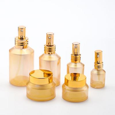 China Luxury personal care glass bottle cosmetic set--skin care cosmetic bottle packaging manufacturer--oblique shoulder with pump&spray&gold cap for sale