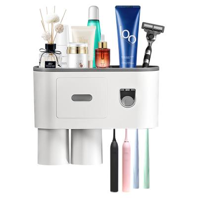 China Wall Mountable Automatic Toothpaste Cup Holder Toothpaste Dispenser Holder Automatic Clamping Toothpaste Dispenser for sale