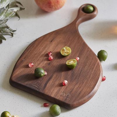 China Sustainable Irregular Shape Kitchen Black Walnut Wood Cutting Serving Board With Handle for sale