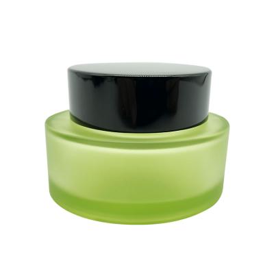 China Luxury Skin Care Unique 50g Oval Shape Olive Color Glass Jars Cosmetic Containers With Black Cap for sale