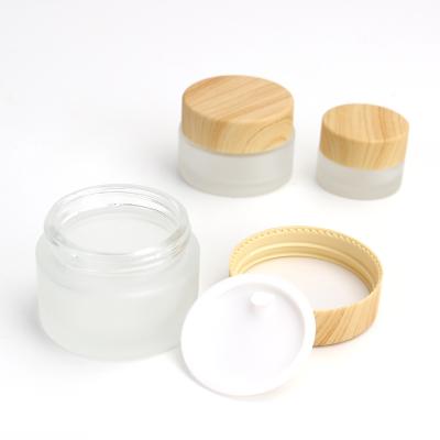 China Clear and frosted glass cosmetic jar eye cream face cream packaging eye cream jar with bamboo wooden pattern cover for sale