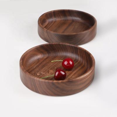 China Sustainable Creative Round Black Walnut Dish Solid Wooden Dishes For Food Fruit Wooden Dinner Dishes for sale