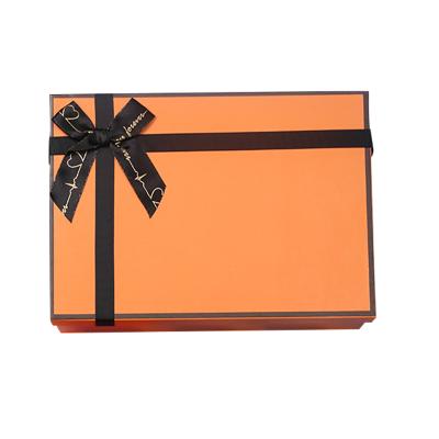 China Recyclable Luxury Elegant Orange Paper Dress Packaging Box Gift Box With Custom Logo Printed Black Ribbon for sale