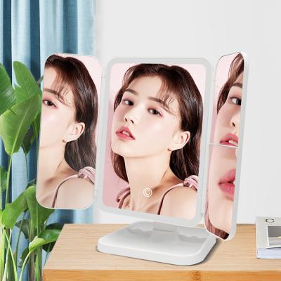 China Trifold Makeup Mirror Lighted Led Charging Folding Rotating Portable Mirror Led Beauty Mirror Three-color Light for sale