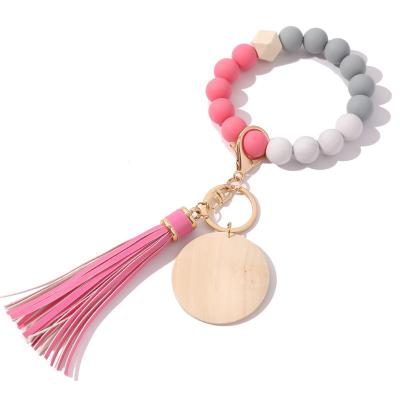 China Plastic Silicon Beads Bracelet Key Chain Monogram Engrave Bracelet Wooden Tassel Laser Blank Disc Key Chains for sale